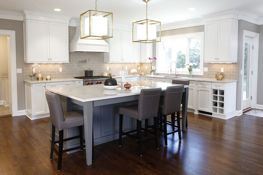 Open-concept white kitchen with warm hardwood floor