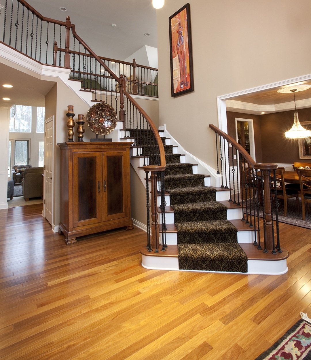 Two-story foyer features open staircase and wood floor