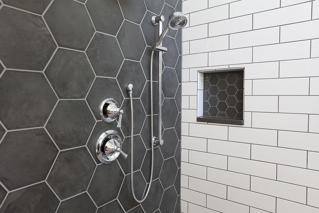 Custom shower enclosure with white and gray tiles, hexagon shapes and glass tile