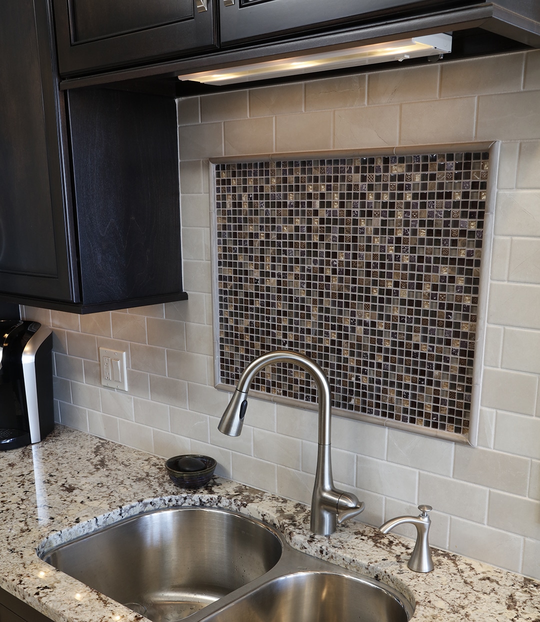 Kitchen backsplash with subway tile and decorative mosaic inlay focal point